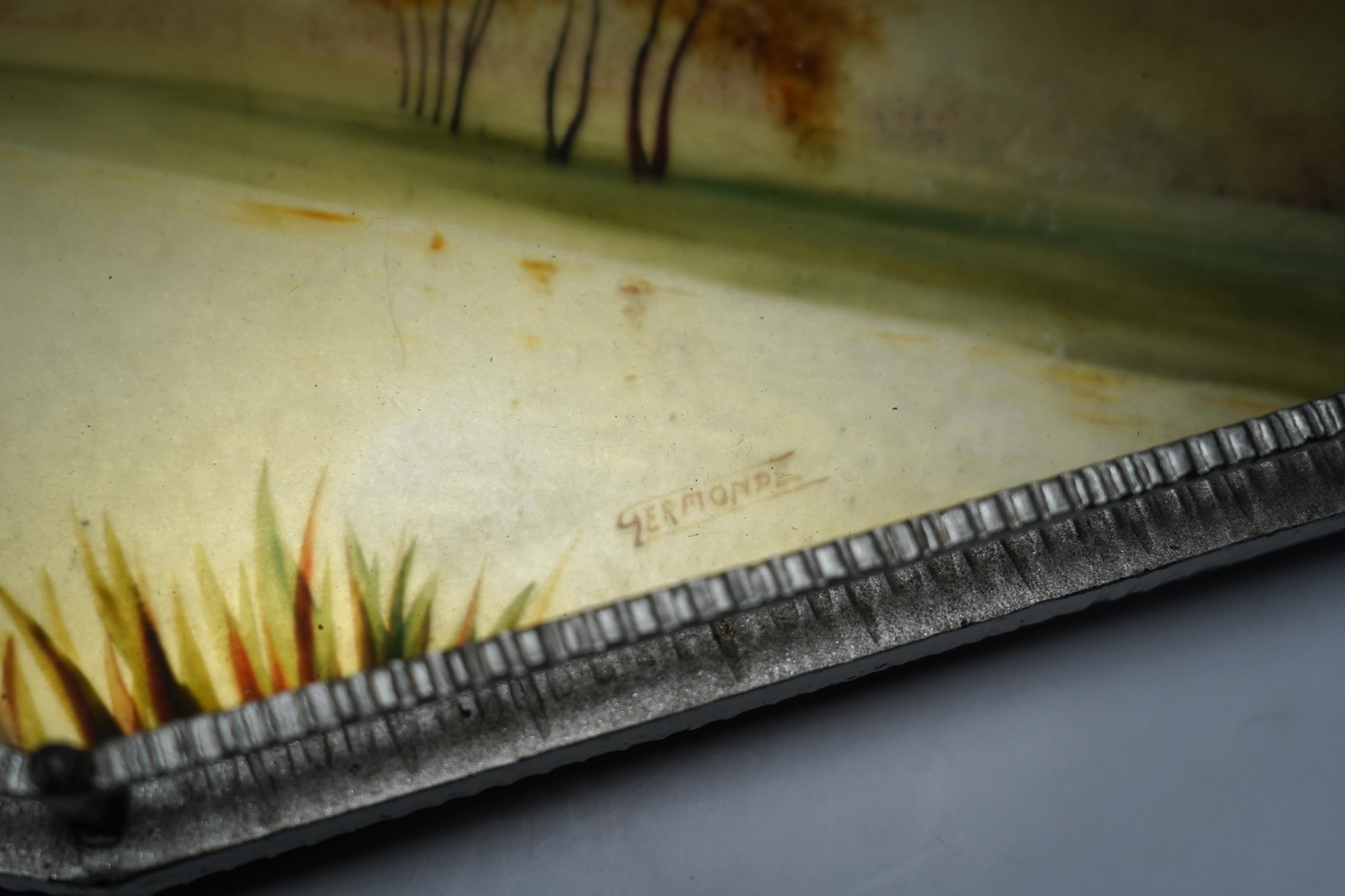 An Art Deco reverse painted and wrought iron tray, with a gallery, centred with a reverse painted landscape scene, signed 'Germonde', 70cm, damaged